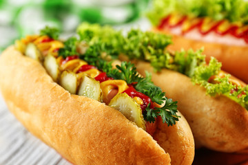 Delicious hot-dogs on white wooden table, close up