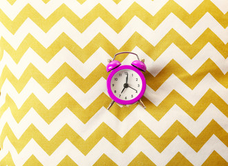 Alarm clock on pillow, close up