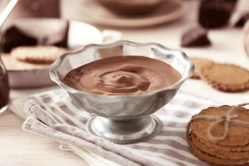 Melted chocolate in bowl, on wooden background