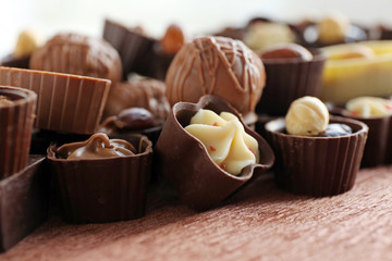 Appetizer chocolate candies on wooden table, close up