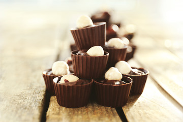 Composition of different chocolate candies on wooden background, close up