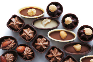 Composition of chocolate candies on white background, close up