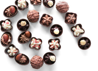 Spiral composition of chocolate candies on white background