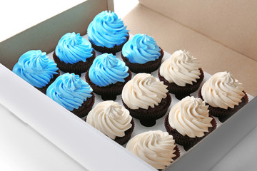 Tasty cupcakes in paper box, close up