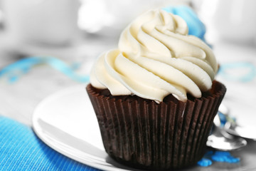 Chocolate cupcakes with colourful cream on served table, close up
