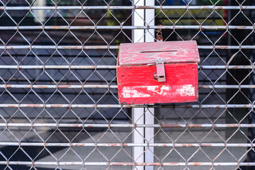 Old wooden postbox hanging on metal doors.