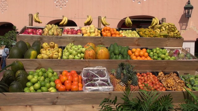 Sunlit fruits in the street market stall by the house wall in Tenerife, Spain

