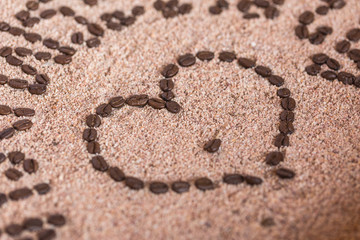 Heart shape made from coffee beans on  on sand