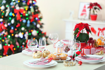 Christmas table setting with holiday decorations on fireplace background