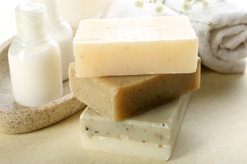 Soap set and towels on a beige background, close up