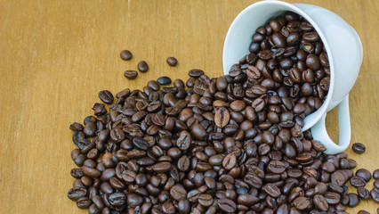 Coffee bean in cup on wooden, selective focus