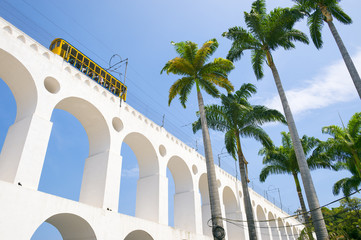Bonde de Santa Teresa tram train drives along distinctive white arches of the landmark Arcos da Lapa Arches in Centro of Rio de Janeiro Brazil