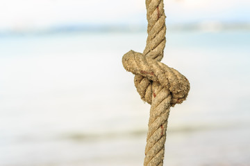 Old rope with tied knot on nature background