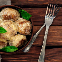 Meatballs with basil leaves in cream sauce
