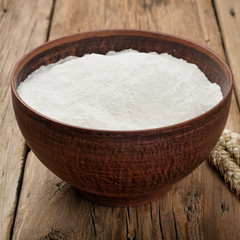 Flour in a bowl on wooden table