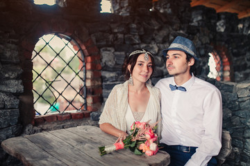 the bride and groom in the castle at a wooden table