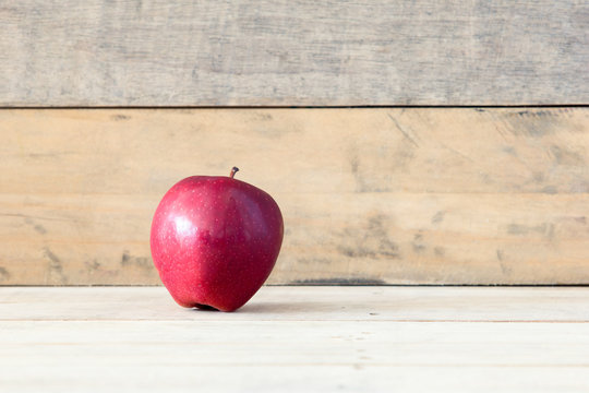Red ripe apple on vintage wooden background