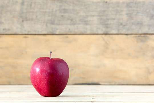 Red ripe apple on vintage wooden background