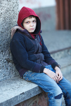 dramatic portrait of a little homeless boy