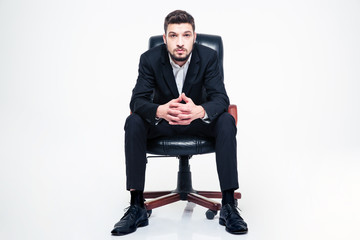 Handsome young businessman with beard sitting in black office chair