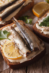 fish Sandwiches with sprats and cream cheese close-up. vertical
