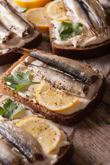 Sandwiches with sprats and cream cheese close-up. vertical
