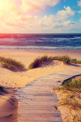 Marine landscape at sunset, wooden pathway to the sea