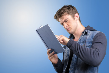 Young man, student reading a book
