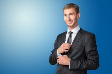 Confident young businessman buttoning cuff sleeves