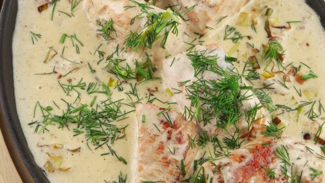 Fish soup with salmon, cream and parsley in a frying pan