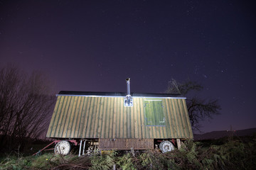 old wooden caravan at night