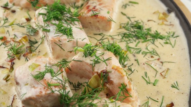 Fish soup with salmon, cream and parsley in a frying pan