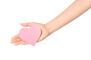 Love and greetings card theme: beautiful female hand holding a paper card pink heart isolated on white background in studio