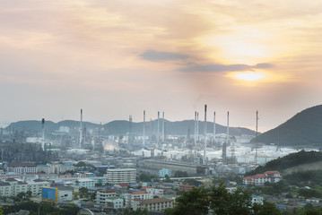 Oil refinery among the city at sunset.