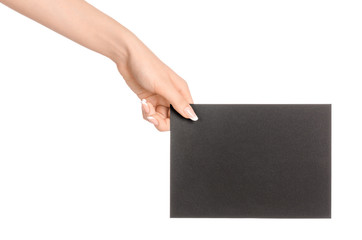 Branding and advertising theme: beautiful female hand holding empty black paper card isolated on white background