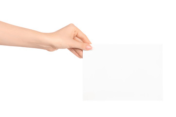 Obraz premium Branding and advertising theme: beautiful female hand holding a blank white paper card isolated on white background