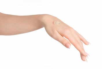 Health and body care theme: beautiful female hand with a transparent scrub cream on a white background isolated