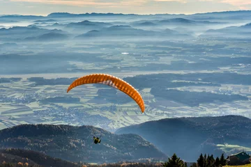 Abwaschbare Fototapete Luftsport Paraglider is flying in the valley
