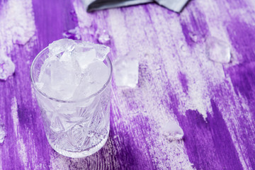 Glass of ice cubes on the wooden background