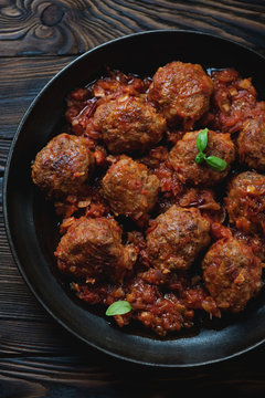 Top view of a frying pan with meatballs in tomato sauce, closeup