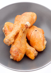 fried chicken thighs in dark porcelain dish