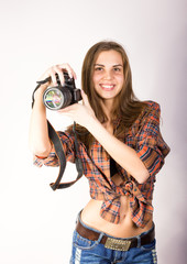 beautiful smiling brunette girl with a camera is dressed in shorts and a shirt