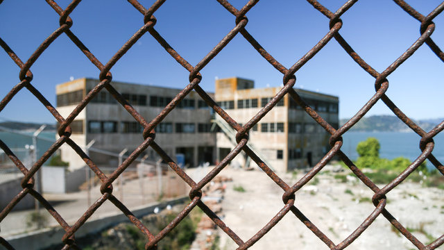 Alcatraz prison seen through chainlink fence, San Francisco, California, America, USA