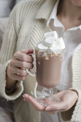 Hands with a cup of cocoa and marshmallows