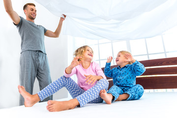 Young nice family making bed