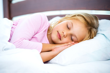 Obraz na płótnie Canvas Little girl sleeping on white bed