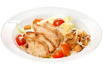 Caesar salad. Chicken meat slices, cheese and vegetables: cherry tomatoes, cabbage, croutons on a white plate on a white background