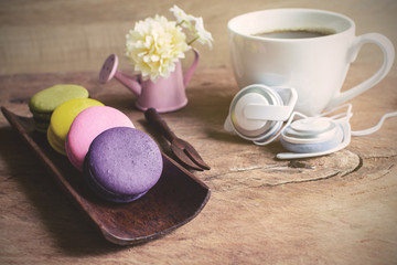Obraz na płótnie Canvas Colorful macaroons and a cup of coffee on wooden table
