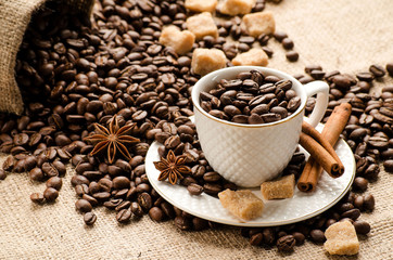 Coffee beans poured into the Cup and saucer and a bag of coffee