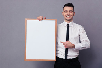 Smiling businessman holding blank board